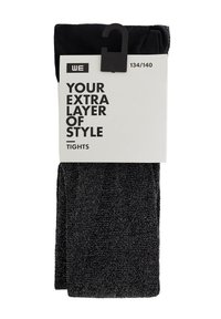 Czarne błyszczące rajstopy złożone, z białą metką z napisem "Twoja dodatkowa warstwa stylu, rajstopy" oraz rozmiarem 134/140, z zawieszką na górze.