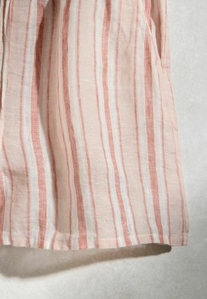 Hellrosa Stoff mit vertikalen weißen und dunkelrosa Streifen, leicht zerknittert, vor einem hellen neutralen Hintergrund.