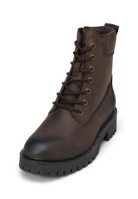 Bruine leren enkelboot met metalen veterogen en bruine veters. Rondneus en robuuste zool met diepe noppen voor grip.