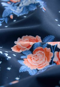 Navy fabric featuring large coral and blue floral patterns with green leaves, smooth texture, and subtle starry accents scattered throughout.