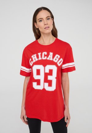 T-shirt rossa in cotone con la scritta "CHICAGO" e "93" in grande carattere bianco, maniche corte con strisce bianche e un design a vestibilità rilassata.