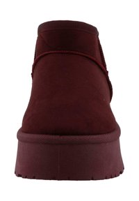 Bottes de cheville en daim bordeaux avec un bout arrondi, des accents élastiques et une semelle en caoutchouc texturée, dotées d'une plateforme surélevée et de détails de couture.