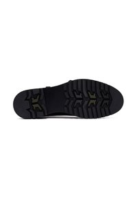 Black sneaker sole with a rugged tread pattern, featuring prominent grooves and embossed logo detail in contrasting color.