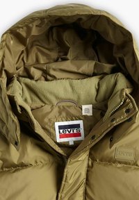 Chaqueta acolchada verde oliva con forro de polar, con capucha, parche del logo de Levi's y texturas contrastantes en el interior del cuello.