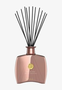 Reed diffuser i en buet glassflaske med rosegull-finish, med svarte reed-pinner og et gull-emblem. Tekst: "WILD FIG PRIVATE COLLECTION."