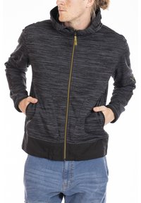 Haut à capuche noir et gris zippé avec un motif texturé, poches avant et accent de fermeture éclair jaune. Design ajusté avec une capuche.