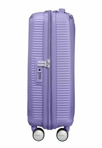 Valigia rigida viola con scanalature verticali, doppia cerniera, lucchetto a combinazione e quattro ruote multidirezionali per una facile manovrabilità.