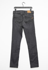 Jeans skinny in denim nero con cinque tasche, passanti per la cintura, una patch in pelle sulla vita posteriore e una texture liscia.