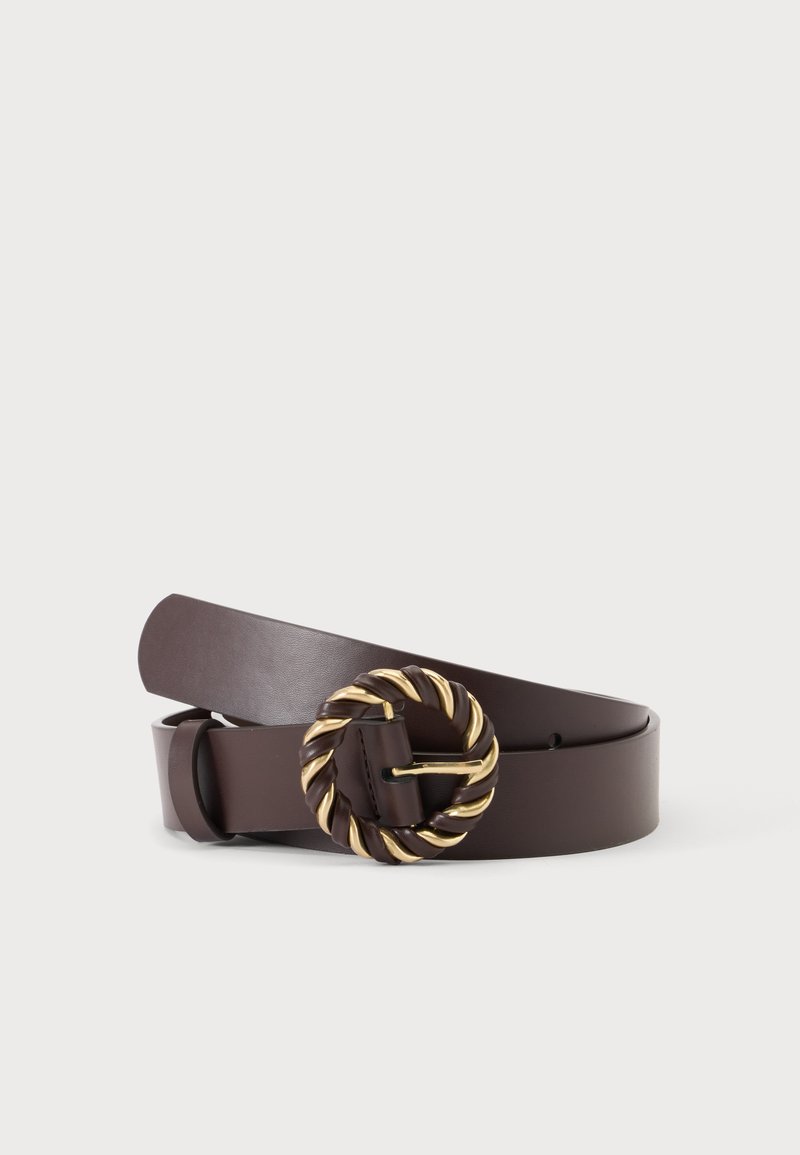 Ceinture en cuir brun foncé avec une boucle circulaire torsadée dorée et brune, posée enroulée sur un fond clair uni.