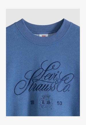 Sininen Levi's-poolopaita, jossa on kirjailtu "Levi Strauss & Co." -teksti ja vaakunalogo, jossa on "18" ja "53" yksityiskohdat.