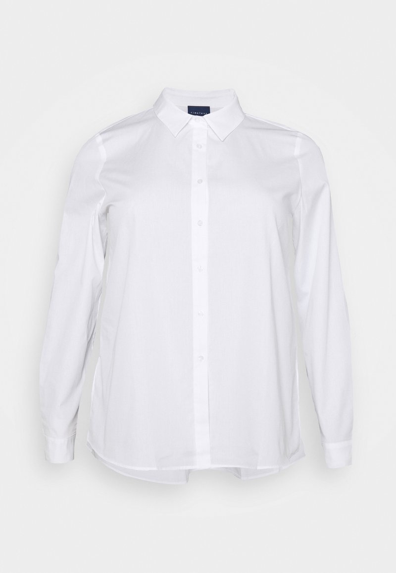 Vitt långärmad skjorta gjord av mjuk bomull. Har en knappstängning framtill, klassisk krage och sidofickor vid fållarna för en avslappnad passform.