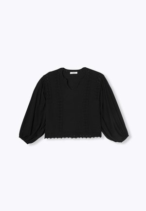 Blouse noire avec un décolleté en V, en tissu texturé et à manches longues bouffantes. Présente des coutures décoratives le long des épaules et de l'ourlet.