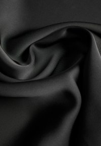 Sile must kangas, millel on pehmed voldid ja õrnad kurrud, luues vooluva ja tekstuurse pinna.