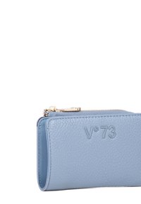 Portafoglio in pelle azzurro chiaro con finitura testurizzata, dotato di una cerniera dorata e del logo "V°73" in rilievo sul davanti. Forma rettangolare compatta.