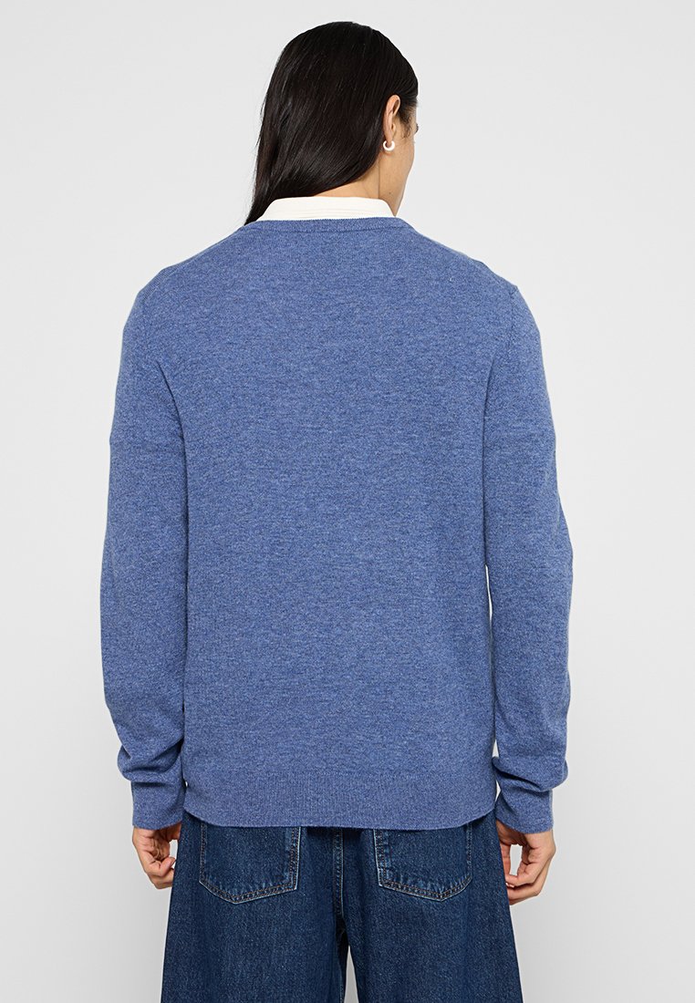 Niebieski sweter dzianinowy z długimi rękawami, prostym okrągłym dekoltem i ściągaczami przy mankietach. Materiał wydaje się miękki i teksturowany.