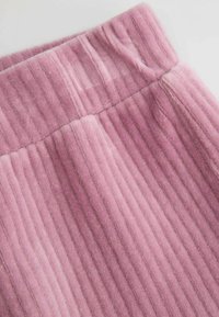 Różowa spódnica z ribbowanej tkaniny, charakteryzująca się miękką fakturą, z pionowymi paskami i elastycznym pasem.