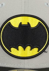 Gray baseball cap featuring a large, embroidered black bat emblem outlined in yellow, with detailed stitching on a textured surface.