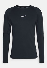 Černé dlouhé rukávy atletické tričko vyrobené z hladkého materiálu. Má kulatý výstřih a bílé logo Nike umístěné na hrudi.