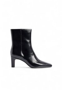 Botín negro de cuero brillante con punta afilada, tacón elevado y textura suave. Presenta un diseño sencillo y sin herrajes visibles.
