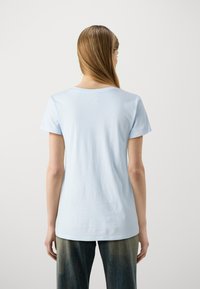 Světle modré bavlněné tričko s krátkými rukávy a kulatým výstřihem, s hladkým povrchem a volným střihem.