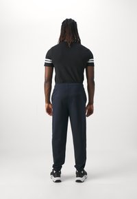 Champion ICONS ELASTIC CUFF PANTS LOOSE FIT - Tepláky - dark blue