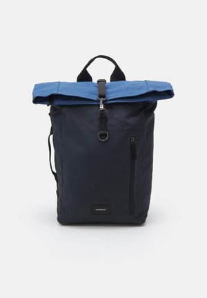 Navyblauwe rugzak met een bovenrolsluiting in lichter blauw, een verticale voorzak met rits, een zwarte band met metalen gesp en een draaghandvat.