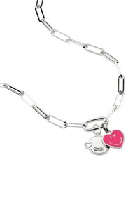 Silberfarbene Kettenhalskette mit länglichen Gliedern; verfügt über zwei Anhänger: ein pinkes Herz und einen silbernen Anhänger mit einem lächelnden Gesichtsumriss.