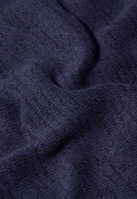 Tessuto a telaio navy con una superficie testurizzata, che presenta modelli sottili e una finitura morbida, caratterizzato da pieghe e grinze delicate.