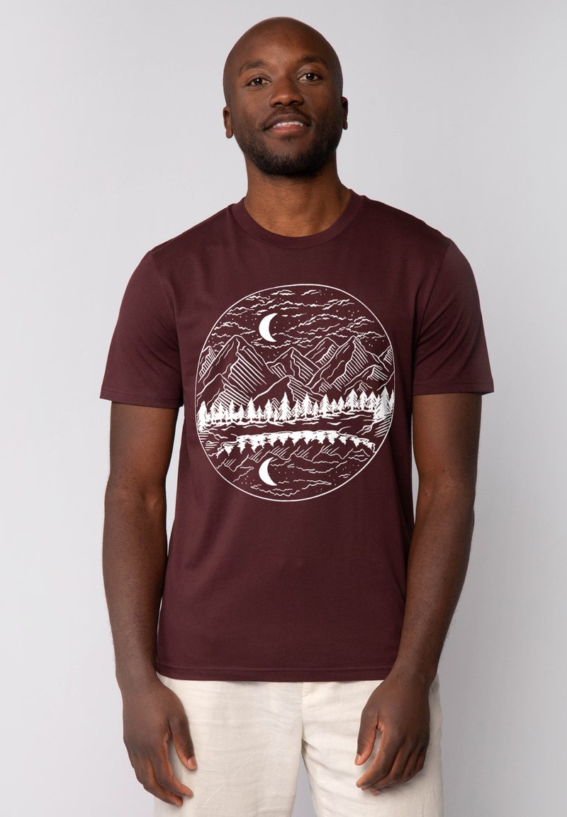 Burgunderfarbendes Baumwoll-T-Shirt mit einem weißen runden Grafikdesign von Bergen und Bäumen sowie Monden. Kurze Ärmel und runder Halsausschnitt.
