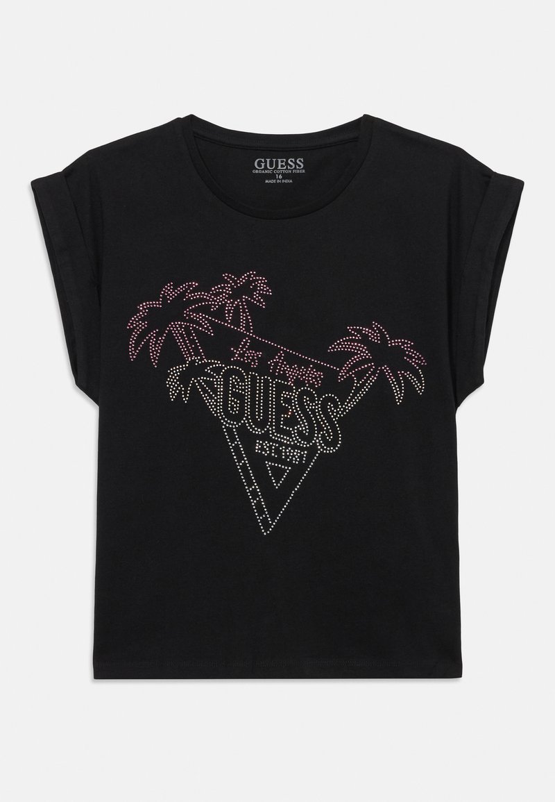 Camiseta de algodón orgánico negra con mangas enrolladas que presenta un gráfico de triángulo de rhinestones, palmeras y el texto "GUESS EST. 1981" en colores vibrantes.