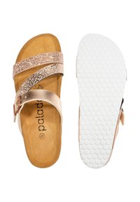 Chanclas con tiras en oro rosa con acentos texturizados y hebilla. Plantilla suave en tono beige con una suela de goma blanca y texturizada.