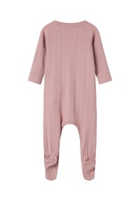 Combinaison bébé rose clair, côtelée, avec des manches longues et des poignets élastiqués aux poignets et aux chevilles, présentée à plat sur un fond blanc.