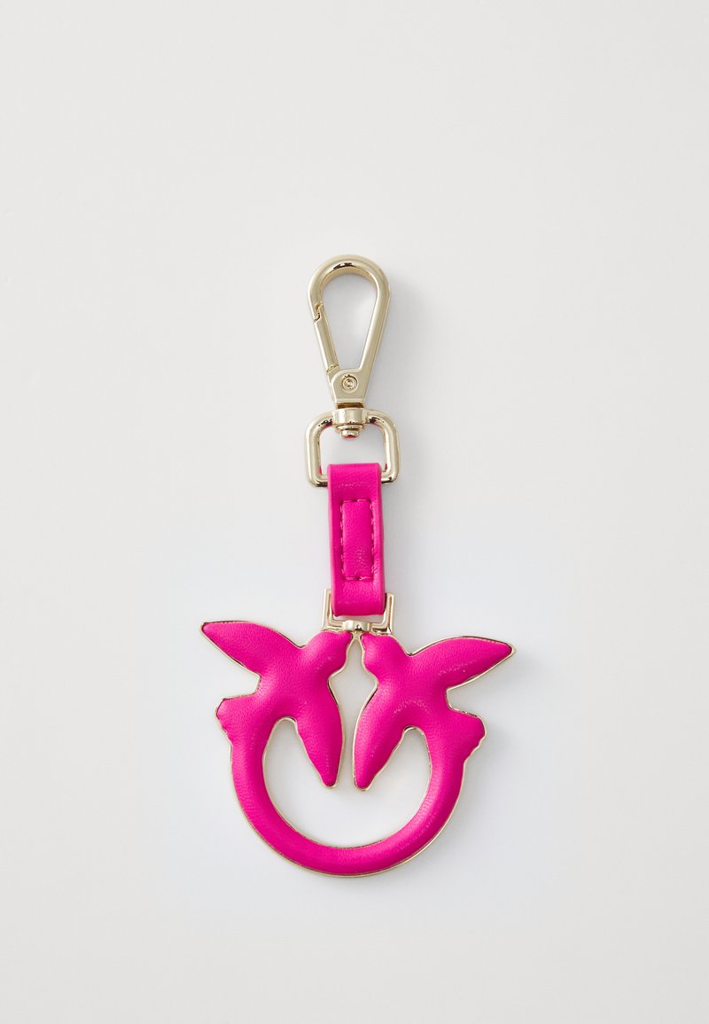 Roza usnjena ključavnica z okroglo zasnovo, ki vsebuje dve obliki ptic. Zlati dodatki so pritrjeni na trak, kar poudarja živo barvo in teksturo.