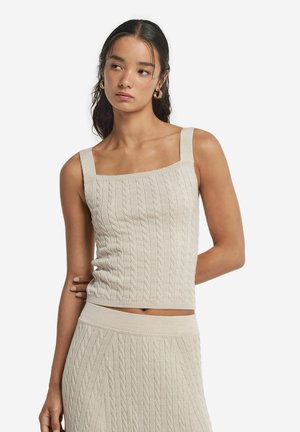 Top corto in maglia beige chiaro con scollo quadrato, spalline spesse e motivo a treccia testurizzato. Tessuto morbido con una vestibilità aderente.