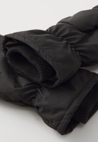 Sorte polstrede handsker med ribbede manchetter. Det yderste materiale er glat, mens manchetterne har et struktureret mønster for varme.