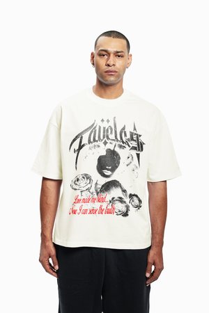 Kremowa oversize t-shirt z graficznym nadrukiem przedstawiającym twarz, róże oraz tekst w kolorze czerwonym i czarnym. Krótkie rękawy, okrągły dekolt, materiał bawełniany.