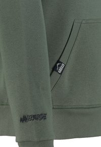 Olivgrüner Sweatshirt mit strukturiertem Finish, ausgestattet mit einer Kängurutasche, gerippten Bündchen und gesticktem "WANDZBURSCHE"-Detail.