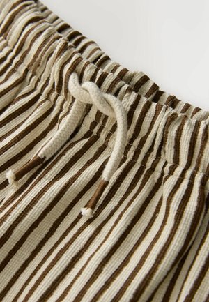 Spodenki z jasnego materiału w naprzemienne brązowe i kremowe paski. Posiadają marszczoną talię z regulowanym sznurkiem.