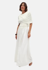 White, floor-length dress made of soft fabric. Features a draped bodice with pleats and a fitted waist, flowing skirt, and short sleeves.
