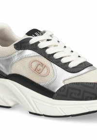 Baskets épaisses avec un mélange de matériaux : maille argentée, accent texturé noir et base crème. Comprend des lacets et un détail logo.