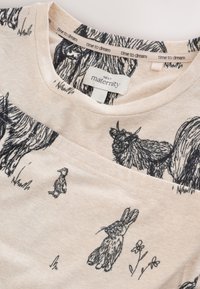 Haut de maternité beige avec dessins au trait noirs d'un lapin, d'un canard et d'une vache des Highlands, étiqueté "Next maternity" et "time to dream."