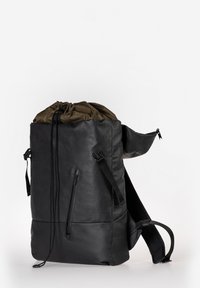 Schwarzer Leder-Rucksack mit einem Schnürverschluss. Verfügt über gepolsterte Schulterriemen, eine Reißverschlusstasche und einen kontrastierenden olivgrünen Deckel.