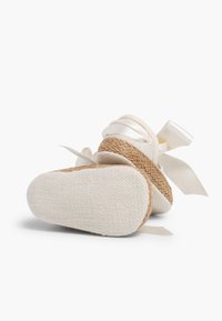 Witte katoenen espadrille met een gevlochten jute zool, met een textuurafwerking en satijnen linten. Ronde neus en een plat zoolontwerp.