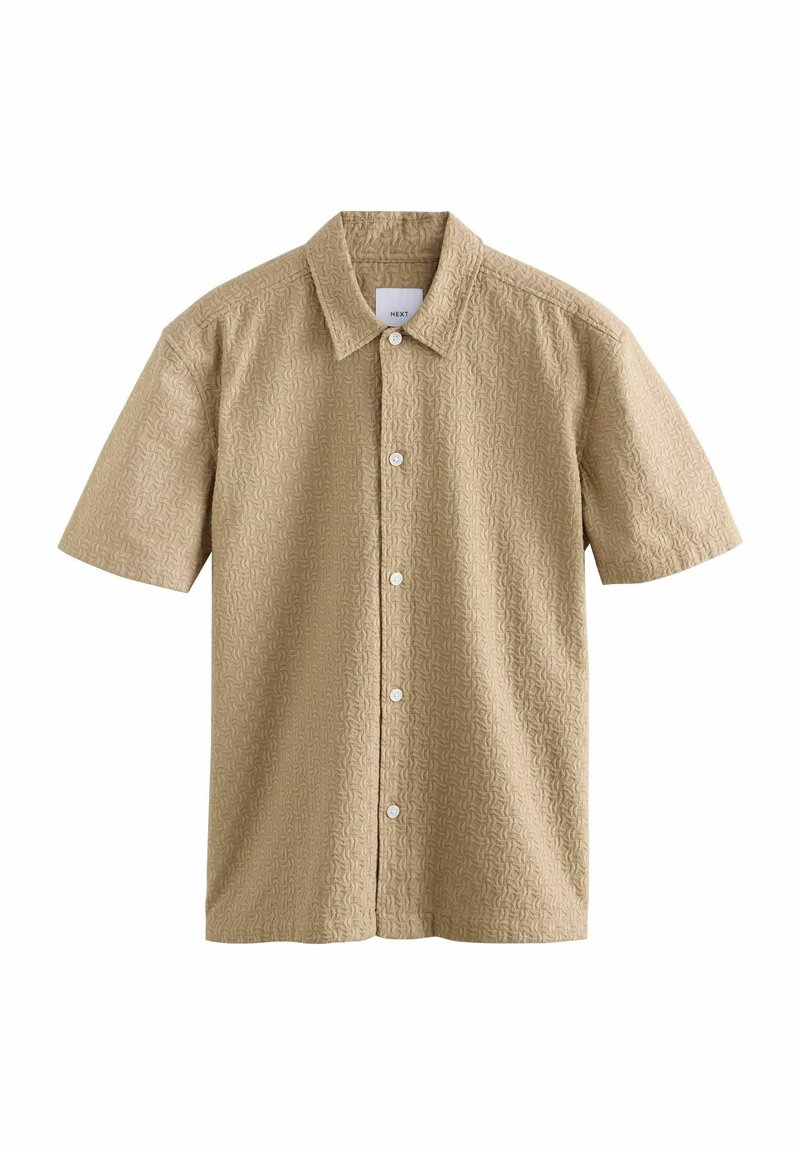 Chemise à manches courtes en tissu beige clair avec un motif texturé, dotée d'un col pointu et de boutons blancs sur le devant.