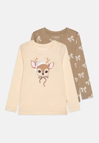 Set of two long-sleeve shirts: one creamy beige with a deer graphic and silver accents; the other light brown with white bow prints.