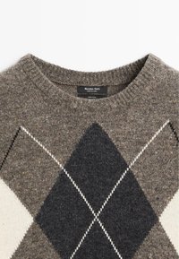 Maglione di lana marrone con motivo argyle in grigio scuro, grigio chiaro e bianco, caratterizzato da un collo rotondo a coste e un'etichetta di marca visibile.