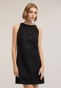 Czarna sukienka bez rękawów o gładkiej fakturze, ozdobiona dekoracyjnym wzorem błyszczących czarnych koralików ułożonych pionowo z przodu.