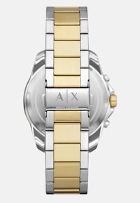 Duotoninis nerūdijančio plieno laikrodžio dirželis su auksinėmis centrą jungtimis ir sidabrinėmis kraštinėmis, turintis "Armani Exchange" užsegimą ir auksinę karūnelę šone.