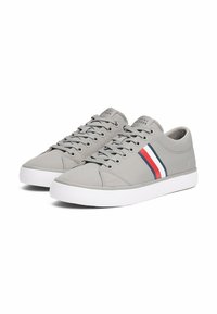 Sneakers in tela grigia con design a basso profilo, suola in gomma bianca e accenti a strisce rosse e blu navale sui lati. Chiusura con lacci.