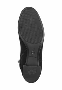 Semelle de botte en suede noir avec une traction en caoutchouc texturé, une marque gravée et un détail de fermeture éclair sur le côté. Taille marquée 37.